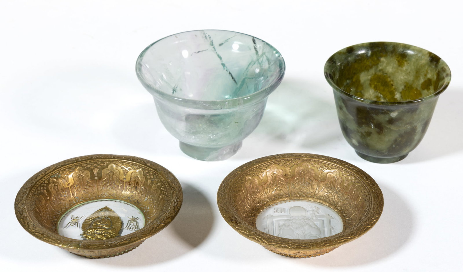 ASSORTED CHINESE OPEN SALTS / CUPS, LOT OF FOUR: ASSORTED CHINESE OPEN SALTS / CUPS, LOT OF FOUR, comprising a jade spinach bowl, a carved Fluorite bowl, and a pair of colorless intaglio bowls with gilt-bronze frames. 20th centur