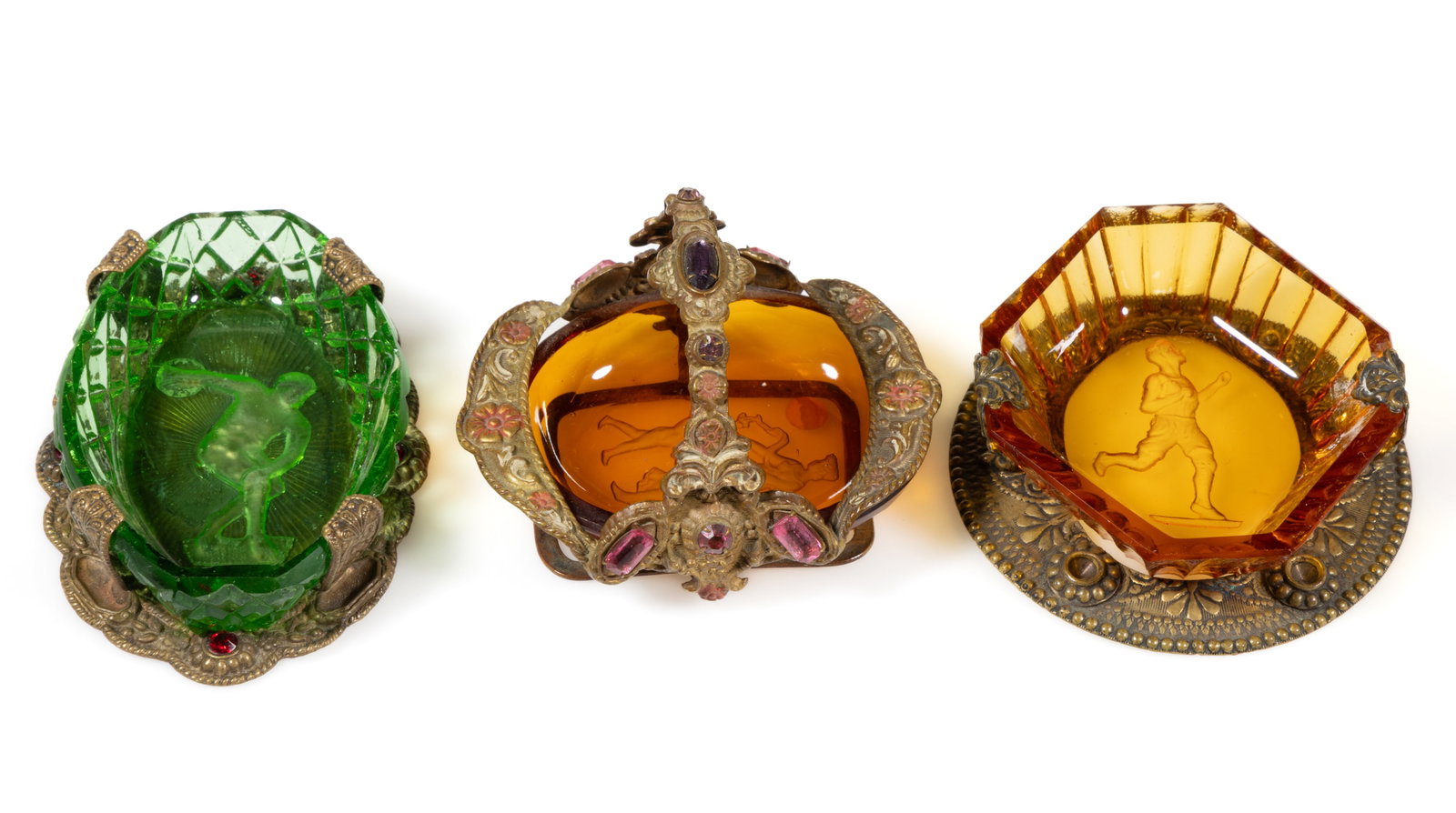 INTAGLIO GLASS OPEN SALTS IN STANDS, LOT OF THREE: INTAGLIO GLASS OPEN SALTS IN STANDS, LOT OF THREE, amber, amethyst, and apple green (reacts under black light), comprising one featuring a discus thrower, one a runner, and one a Classical scene, each