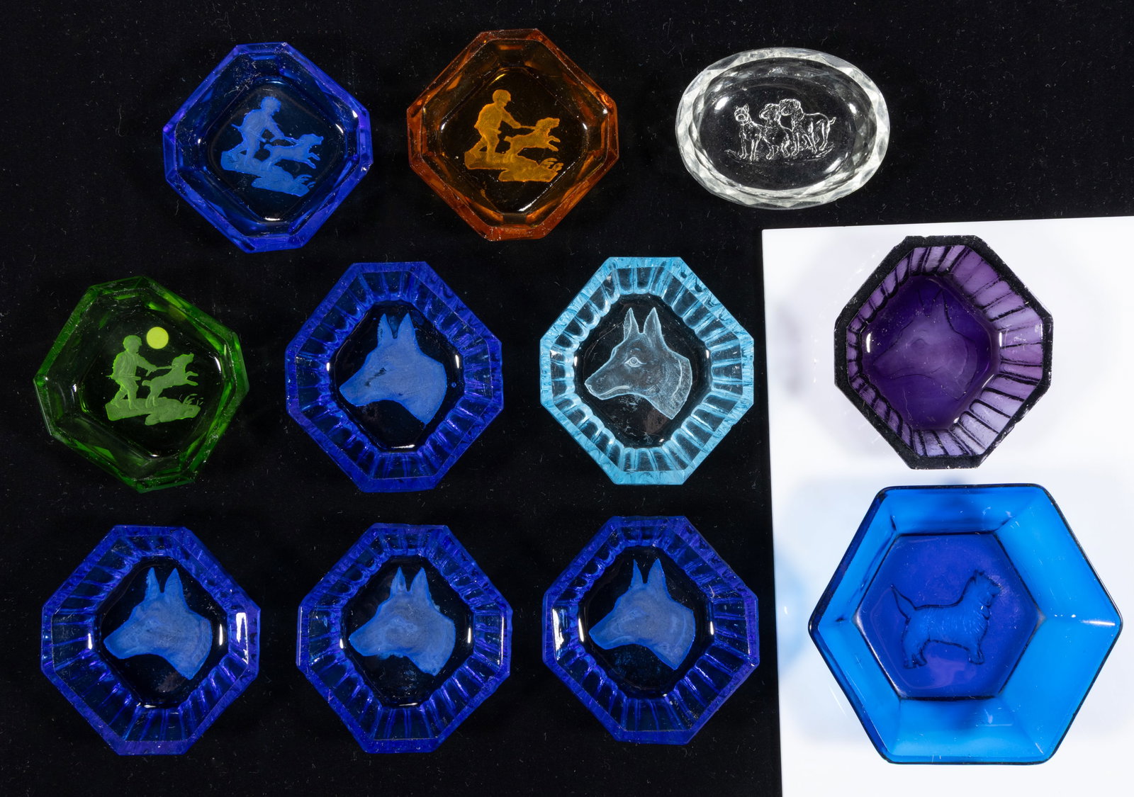 INTAGLIO GLASS OPEN SALTS, LOT OF 11: INTAGLIO GLASS OPEN SALTS, LOT OF 11, various colors, comprising various dog examples, each having a factory-polished rim and edge. Czechoslovakia. Circa 1930. 2 1/8" to 3 1/2" DOA. Literatu
