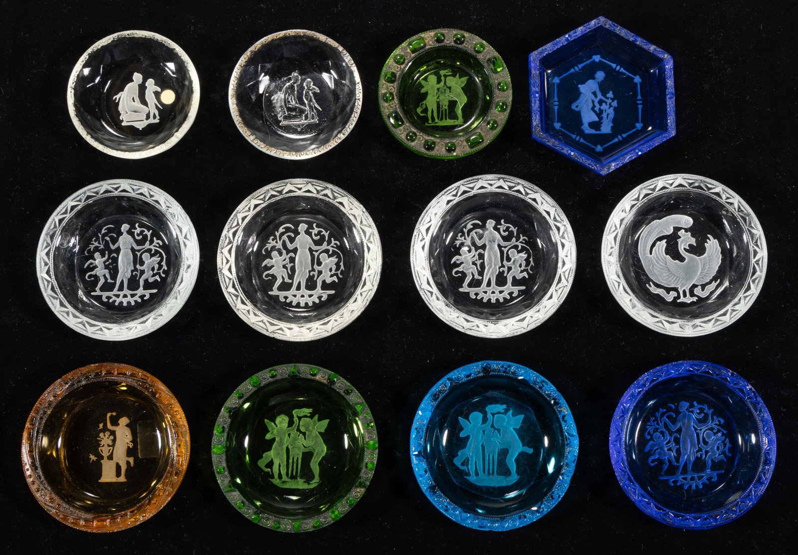 INTAGLIO EMBOSSED EDGE GLASS OPEN SALTS, LOT OF 12: INTAGLIO EMBOSSED EDGE GLASS OPEN SALTS, LOT OF 12, various colors, most featuring Classical figures and one featuring a phoenix, each having a decorated rim. Czechoslovakia. Circa 1930. 2 1/4&qu