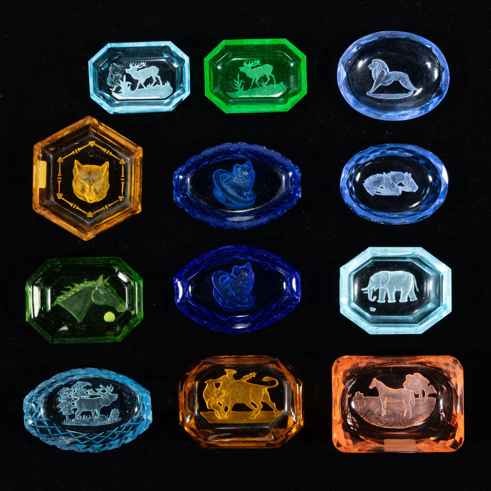INTAGLIO GLASS OPEN SALTS, LOT OF 12: INTAGLIO GLASS OPEN SALTS, LOT OF 12, various colors including one apple green (reacts under black light), including one featuring a matador and bull, an elephant, a horse, a lion, and a wolf, each ha