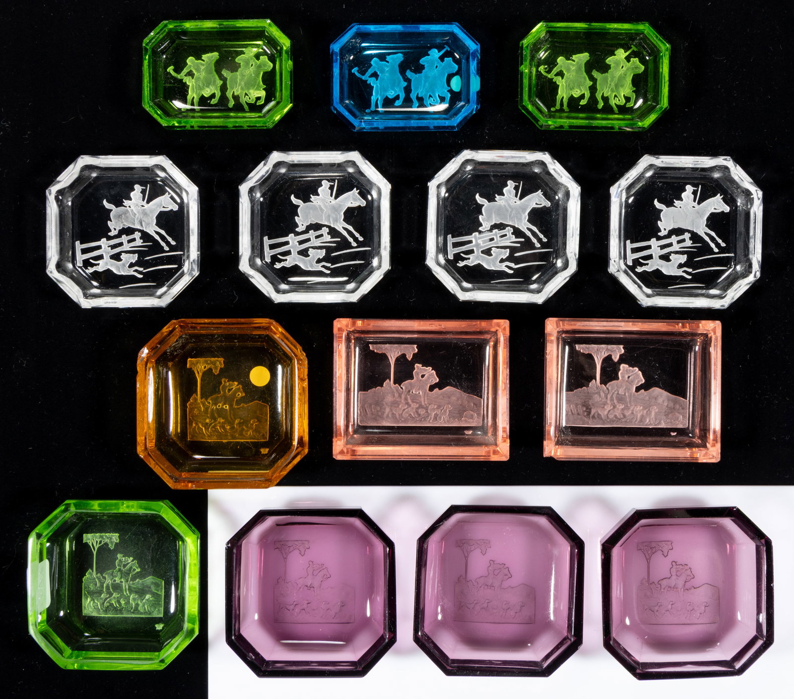 INTAGLIO GLASS OPEN SALTS, LOT OF 14: INTAGLIO GLASS OPEN SALTS, LOT OF 14, various colors, each depicting an equestrian scene, including three featuring polo ponies, and four with hunter and horse jumping a fence with a dog, ea