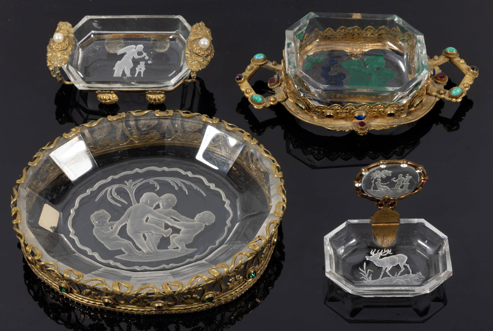ASSORTED INTAGLIO GLASS ARTICLES, LOT OF FOUR: ASSORTED INTAGLIO GLASS ARTICLES, LOT OF FOUR, colorless, comprising two open salts in gilt-metal stands one featuring a Classical scene, the other berries painted to the underside, one place car