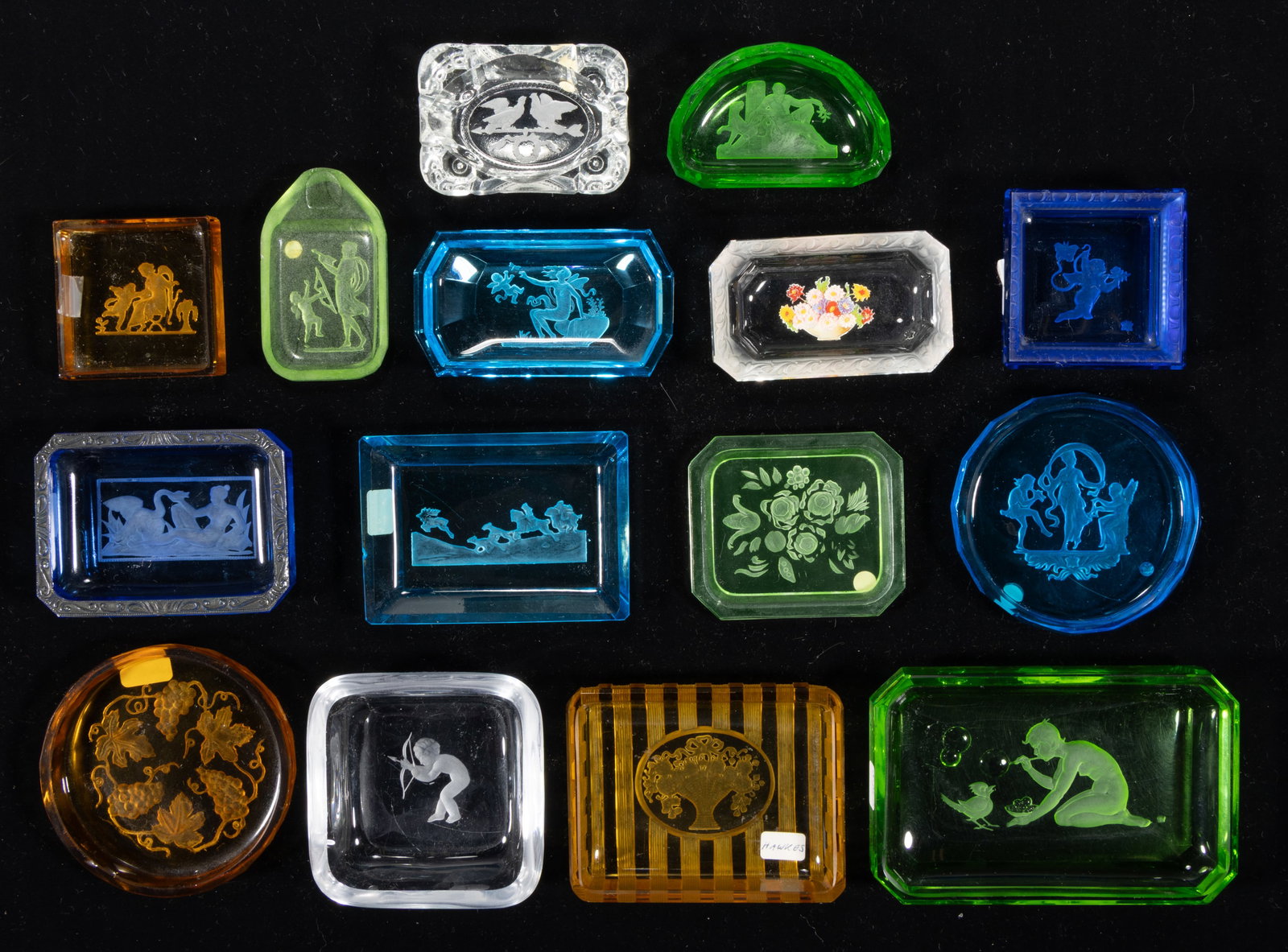 ASSORTED INTAGLIO GLASS ASHTRAYS, LOT OF 15: ASSORTED INTAGLIO GLASS ASHTRAYS, LOT OF 15, various colors including two apple green (reacts under black light), including seven examples featuring Classical scenes, two featuring a putto, and one a 
