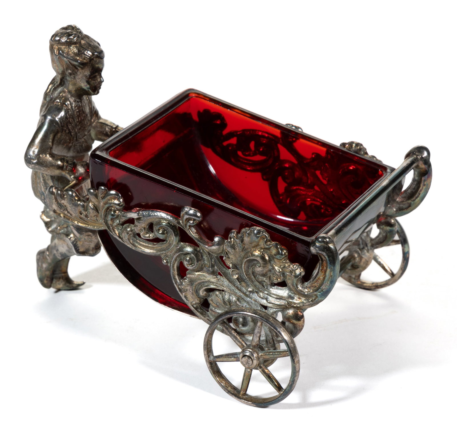 FIGURAL CART SILVER-PLATED OPEN SALT: FIGURAL CART SILVER-PLATED OPEN SALT, ruby glass insert, featuring a Victorian-style lady pushing a cart with scrolled sides and two wheels. Underside with hand-etched "2027-X", otherwise un