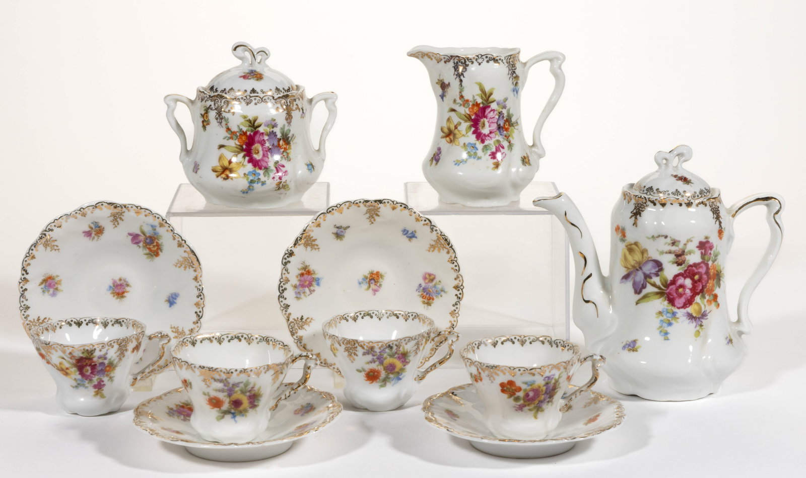 GERMANY PROV SAXE CHILDREN'S FLORAL MOTIF PORCELAIN 11-PIECE TEA SET: GERMANY PROV SAXE CHILDREN'S FLORAL MOTIF PORCELAIN 11-PIECE TEA SET, each having bright polychrome transfer featuring assorted flowers and a gilt scroll border, comprising a teapot, a covered sug