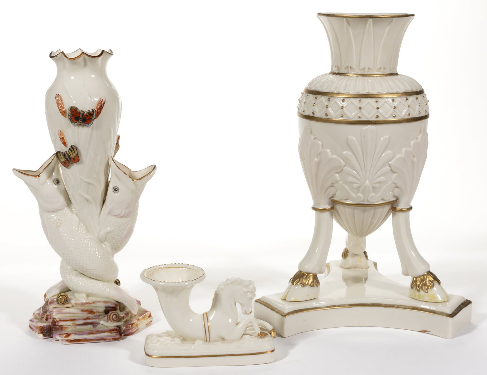 IRISH BELLEEK PORCELAIN VASES, LOT OF THREE: IRISH BELLEEK PORCELAIN VASES, LOT OF THREE, comprising an amphora-form example resting on the three cloven hooves, a double fish-form example resting on a molded rocky base with snails, and a sm