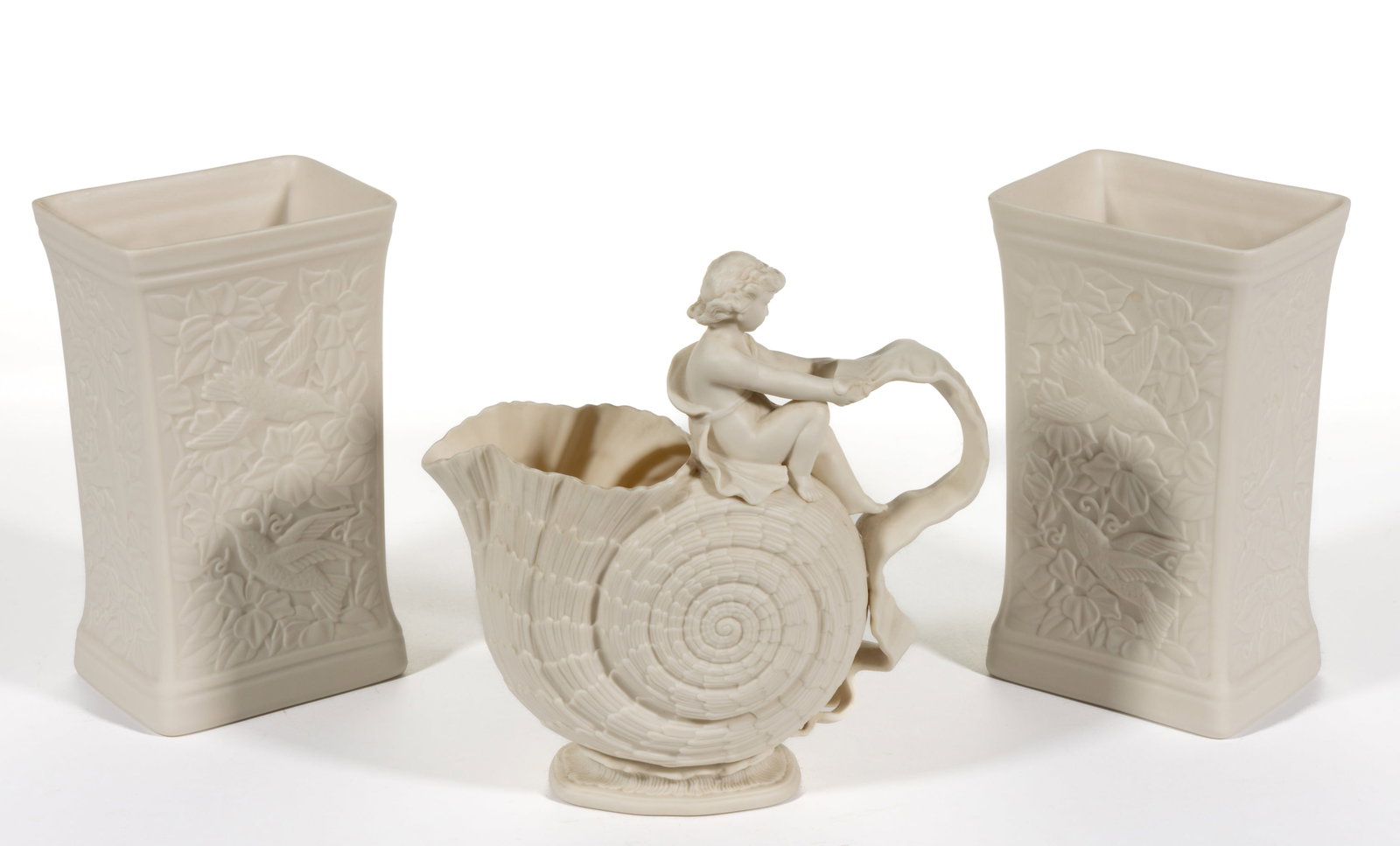 AMERICAN LENOX CHINA PROTOTYPE BISQUE PORCELAIN ARTICLES, LOT OF THREE: AMERICAN LENOX CHINA PROTOTYPE BISQUE PORCELAIN ARTICLES, LOT OF THREE, comprising a Walter Scott Lenox designed pitcher depicting a child/putto resting at the top of a nautilus shell and holding a ri