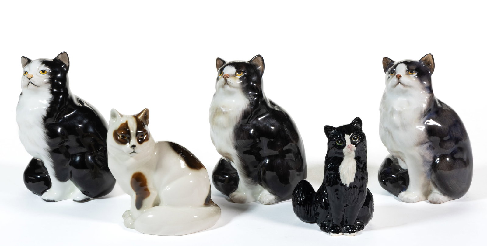 AUSTRIAN AND ENGLISH HAND-PAINTED CERAMIC CAT FIGURES, LOT OF FIVE: AUSTRIAN AND ENGLISH HAND-PAINTED CERAMIC CAT FIGURES, LOT OF FIVE, each in sitting form, comprising a Keramos Wien brown and white example and four Royal Doulton black and white examples. Marks 