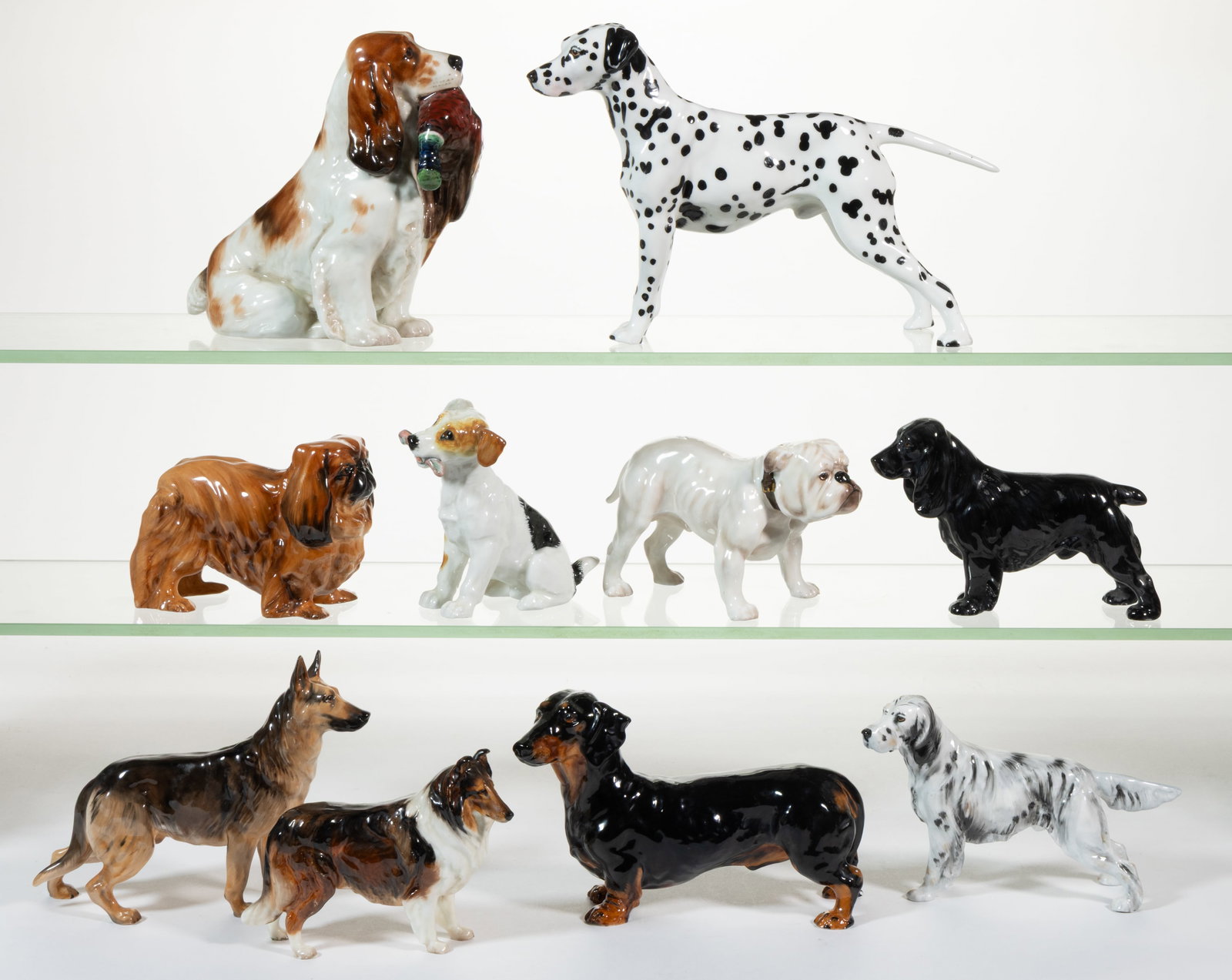 ENGLISH ROYAL DOULTON HAND-PAINTED PORCELAIN DOG FIGURES, LOT OF TEN: ENGLISH ROYAL DOULTON HAND-PAINTED PORCELAIN DOG FIGURES, LOT OF TEN, comprising one sitting spaniel holding a pheasant in its mouth, a standing Dalmatian, one English Bulldog, one Collie, one German 