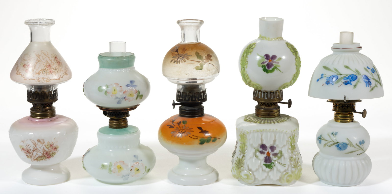 ASSORTED DECORATED OPAQUE GLASS MINIATURE LAMPS, LOT OF SIX: ASSORTED DECORATED OPAQUE GLASS MINIATURE LAMPS, LOT OF SIX, opaque white with various polychrome decorations, patterns comprising of an Apple Blossom/Smith I, fig. 194; a Nellie Bly/Smith I, fig. 279