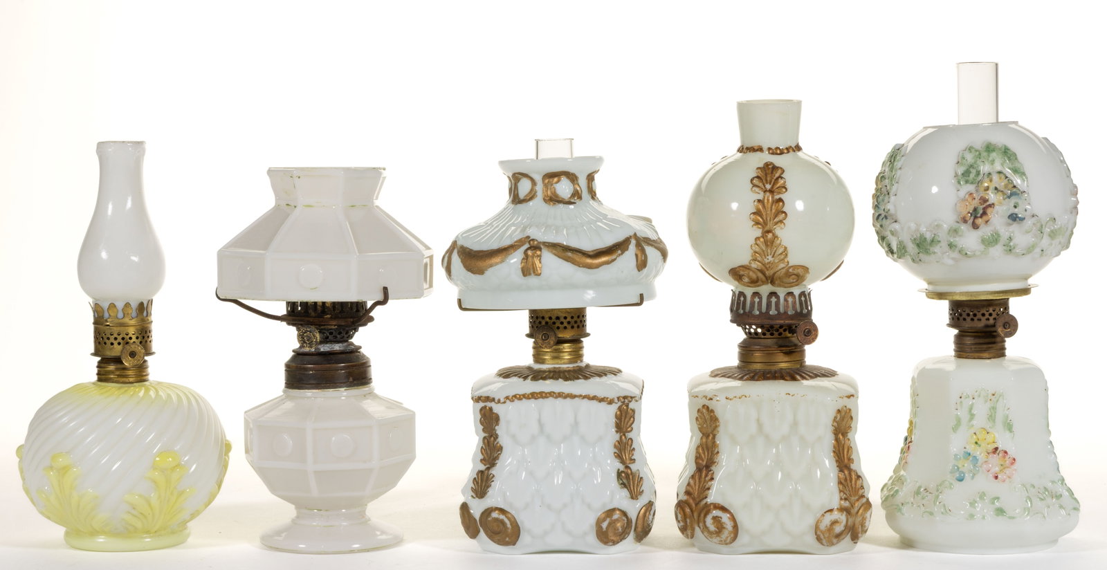 ASSORTED PATTERN MINIATURE LAMPS, LOT OF FIVE: ASSORTED PATTERN MINIATURE LAMPS, LOT OF FIVE, opaque white/milk glass, four with original decoration, four with matching shade. Each with a period burner, three with a chimney. Late 19th/first quarte