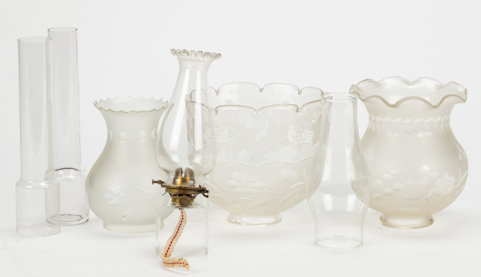 ASSORTED KEROSENE LIGHTING SETUP COMPONENTS, LOT OF SEVEN: ASSORTED KEROSENE LIGHTING SETUP COMPONENTS, LOT OF SEVEN, comprising of three colorless with frosted finish shades, each having engraved foliage and floral patterns, incudes a cylinder-form with a 2 