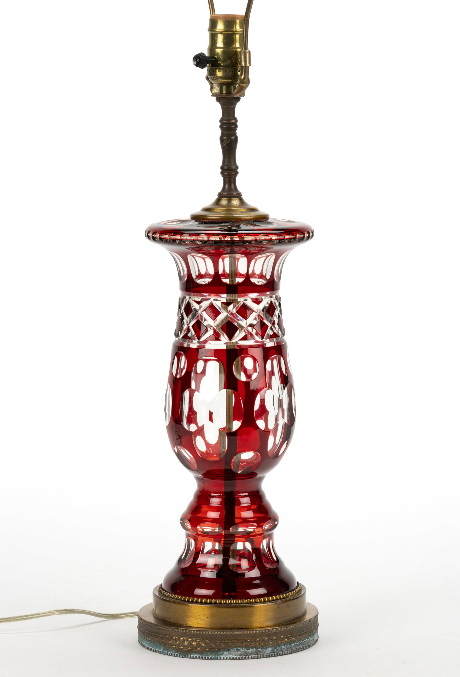 CUT OVERLAY PANEL AND QUATREFOIL ELECTRIC TABLE LAMP: CUT OVERLAY PANEL AND QUATREFOIL ELECTRIC TABLE LAMP, baluster-form stem with ovals over diamonds and over quatrefoils, brass mounts. Fitted with a tan silk-like fabric and paneled lamp shade. Current