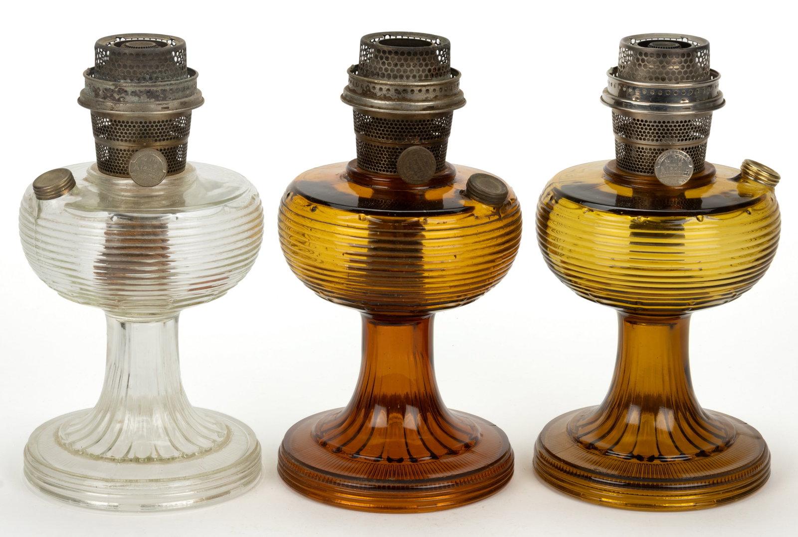ALADDIN MODEL B-80 AND B-82 / BEEHIVE KEROSENE STAND LAMPS, LOT OF THREE: ALADDIN MODEL B-80 AND B-82 / BEEHIVE KEROSENE STAND LAMPS, LOT OF THREE, comprising of a dark Amber Beta Crystal, an Amber light Olive Green and a Clear Beta Crystal, each with a 