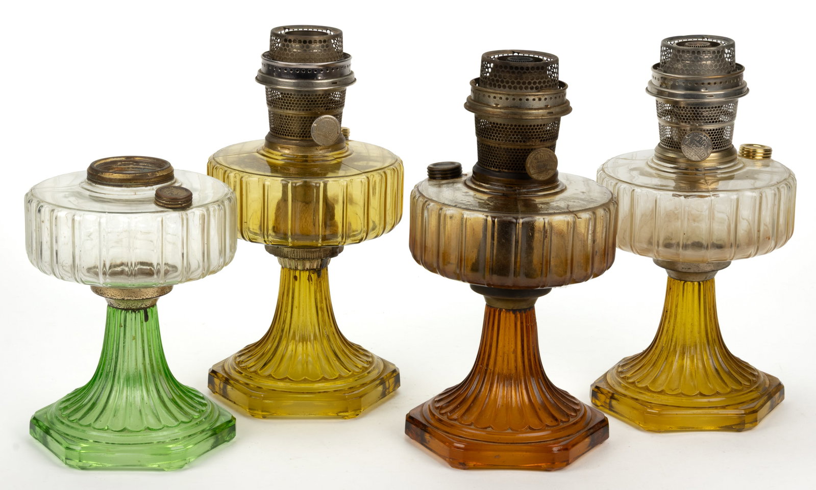 ALADDIN MODEL B101, B-105, AND B-106 / CORINTHIAN KEROSENE STAND LAMPS, LOT OF FOUR: ALADDIN MODEL B101, B-105, AND B-106 / CORINTHIAN KEROSENE STAND LAMPS, LOT OF FOUR, comprising of two Amber Beta Crystal examples in dark and light; a Clear Beta Crystal font with Green Crystal base;
