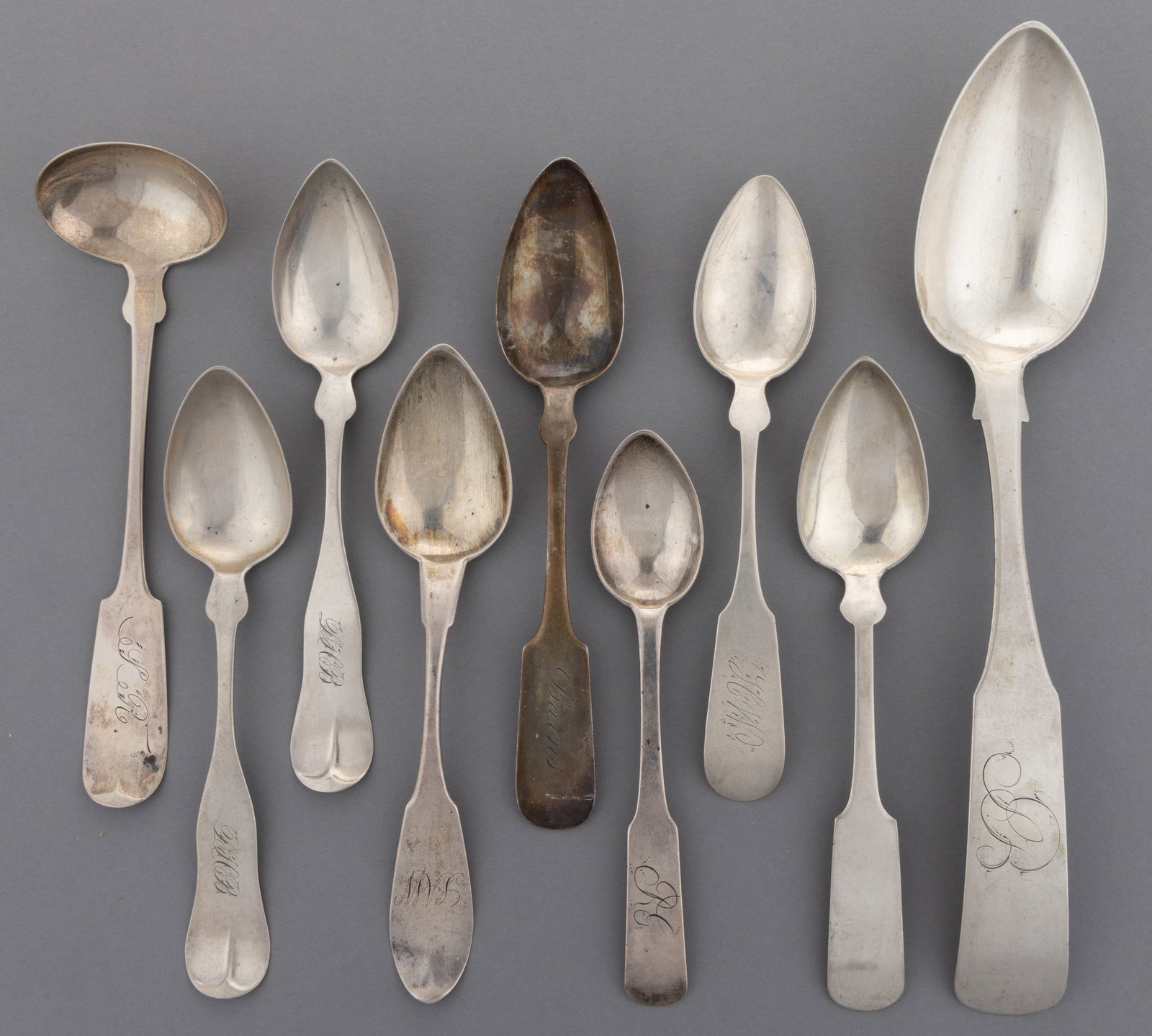 NEW ENGLAND COIN SILVER SPOONS AND CREAM LADLE, LOT OF NINE: NEW ENGLAND COIN SILVER SPOONS AND CREAM LADLE, LOT OF NINE, each piece having a fiddle handle, most with personalized engravings; comprising a tablespoon by Edward F. Miller of Providence, RI (active