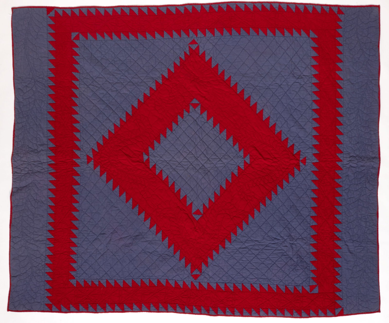 AMISH-STYLE "SAWTOOTH DIAMOND" PIECED QUILT: AMISH-STYLE "SAWTOOTH DIAMOND" PIECED QUILT, hand- and machine-stitched, completed in solid red and blue fabrics, a large central sawtooth diamond to center surrounded by a sawtooth frame,