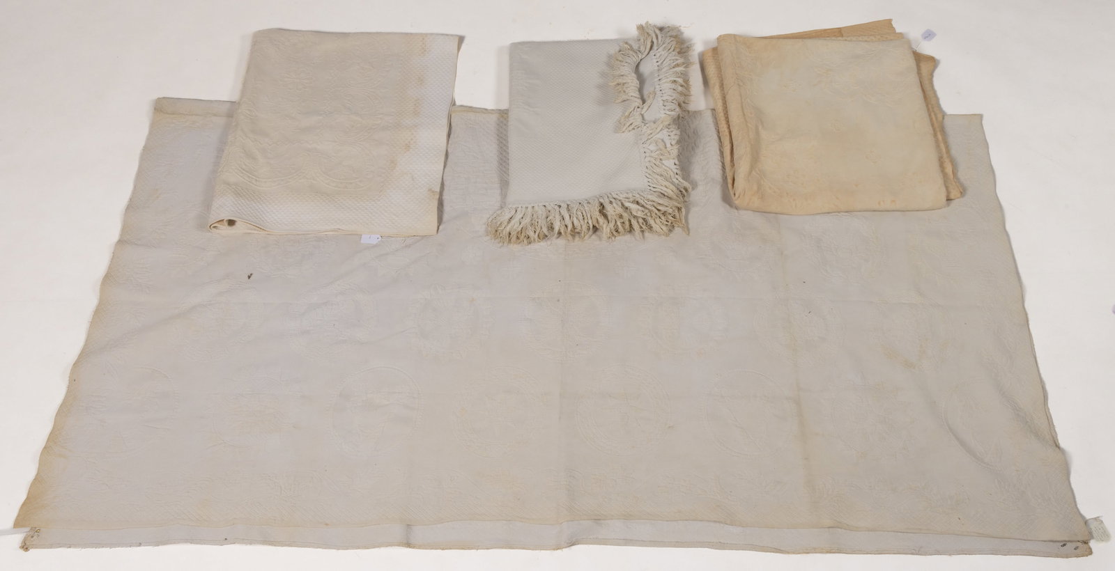 ANTIQUE MARSEILLE-TYPE COUNTERPANES / BED COVERS, LOT OF FOUR: ANTIQUE MARSEILLE-TYPE COUNTERPANES / BED COVERS, LOT OF FOUR, each woven white cotton stuffed with cord; including one with a large central medallion surrounded by smaller medallions of motifs includ
