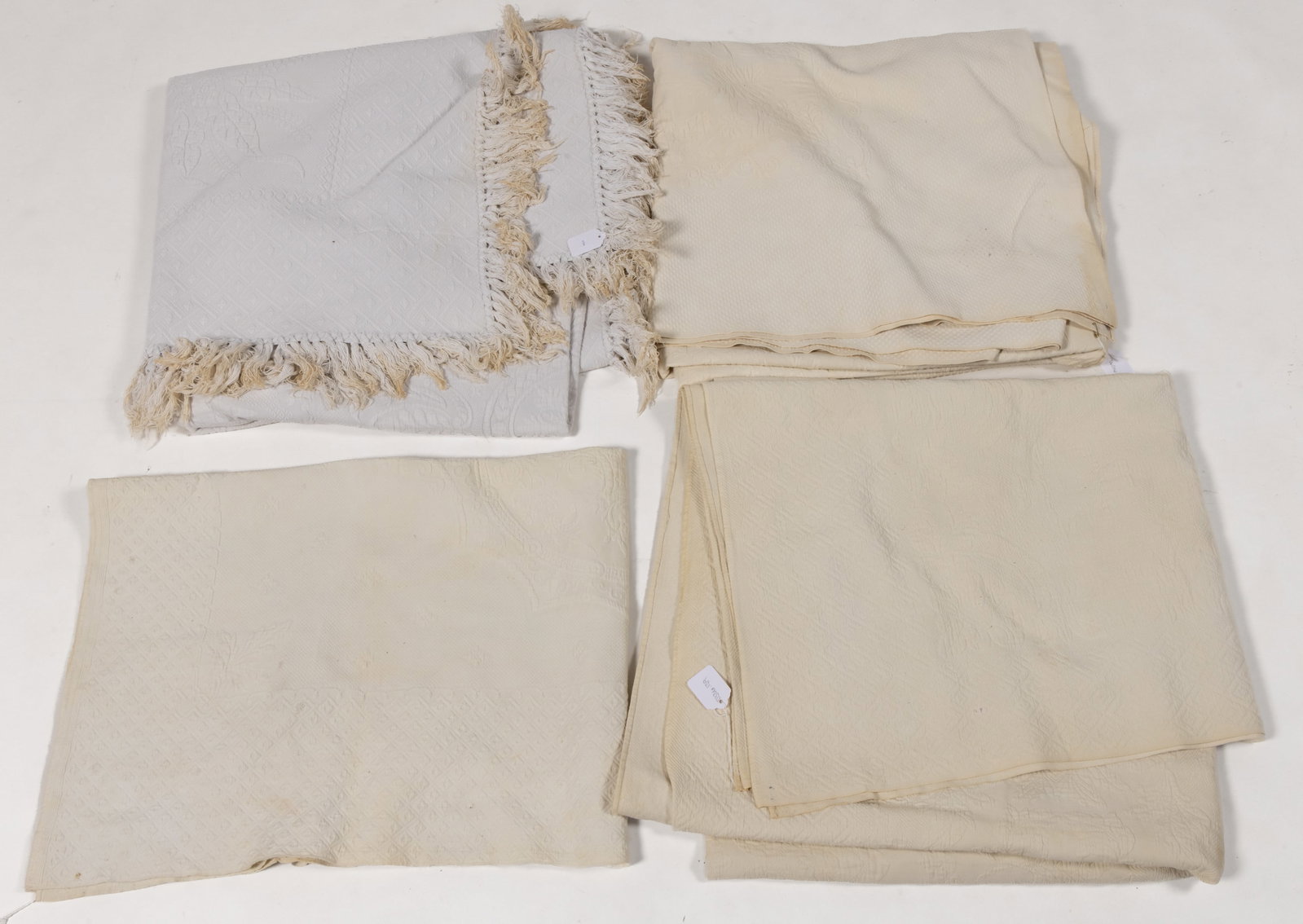 ANTIQUE MARSEILLE-TYPE COUNTERPANES / BED COVERS, LOT OF FOUR: ANTIQUE MARSEILLE-TYPE COUNTERPANES / BED COVERS, LOT OF FOUR, each woven white cotton stuffed with cord; comprising a crib example having a central shield with stars and stripes; one with a bota
