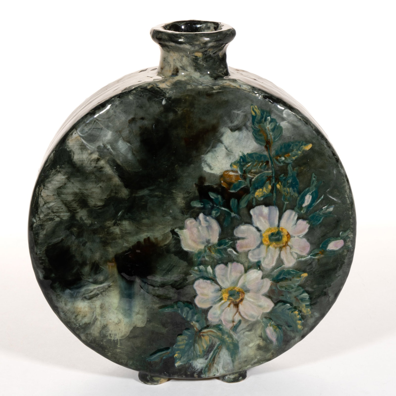 RETTING-VALENTIEN POTTERY CINCINNATI, OHIO LIMOGES CANTEEN VASE: RETTING-VALENTIEN POTTERY CINCINNATI, OHIO LIMOGES CANTEEN VASE, flat, circular form with four short, circular feet, featuring polychrome light pink and white flowers on mottled dark green and wh