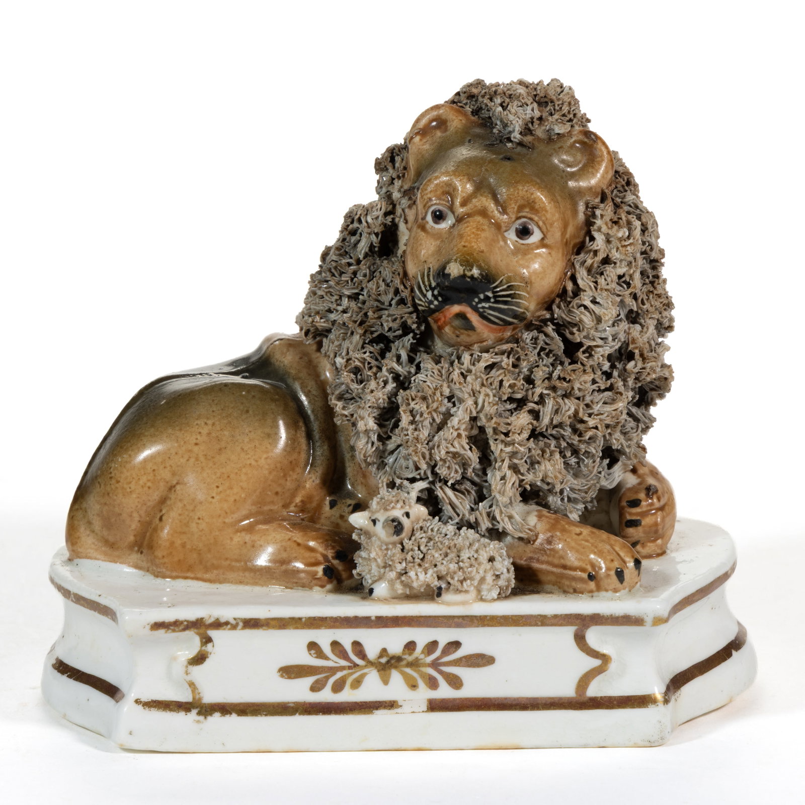 ENGLISH STAFFORDSHIRE PORCELAIN LION AND LAMB FIGURAL GROUP: ENGLISH STAFFORDSHIRE PORCELAIN LION AND LAMB FIGURAL GROUP, having polychrome hand-painted decorations, featuring a recumbent lion with shredded clay mane and a small lamb, resting on a waisted 