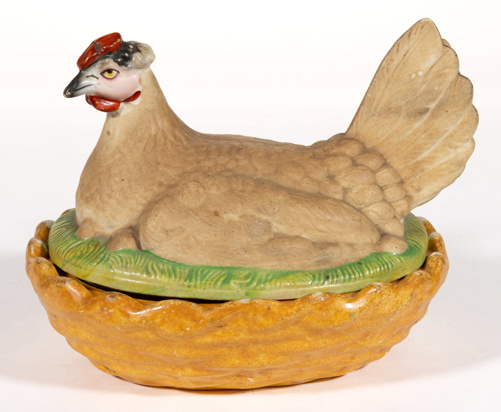 CONTINENTAL PORCELAIN HAND-PAINTED CHICKEN ON NEST COVERED DISH: CONTINENTAL PORCELAIN HAND-PAINTED CHICKEN ON NEST COVERED DISH, having polychrome decorations including feathers, a red comb and wattle, and sitting on eggs nestled in grass in a molded bas