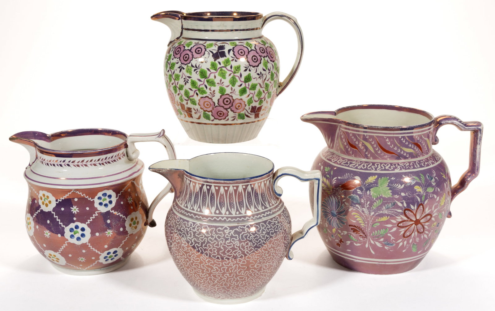 BRITISH PINK LUSTRE HAND-PAINTED CERAMIC JUGS / PITCHERS, LOT OF FOUR: BRITISH PINK LUSTRE HAND-PAINTED CERAMIC JUGS / PITCHERS, LOT OF FOUR, comprising one example featuring groups of simple pink flowers and leafy vine designs and three examples with resist decorations 