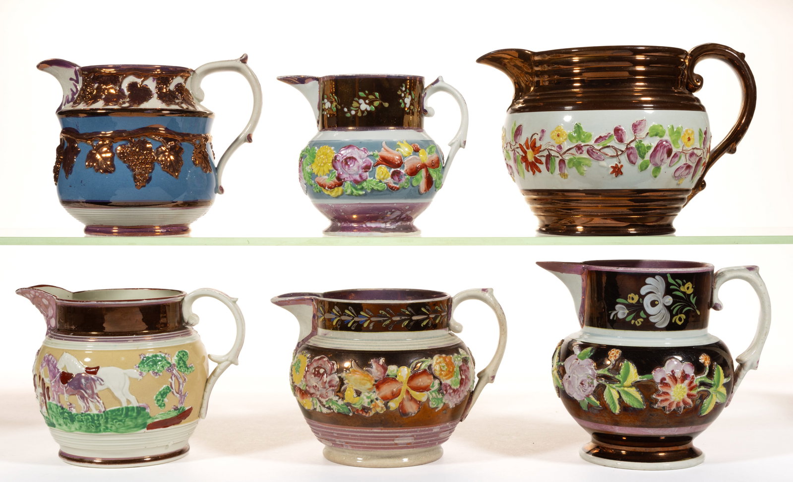 BRITISH LUSTRE AND RELIEF-DECORATED CERAMIC JUGS / PITCHERS, LOT OF SIX: BRITISH LUSTRE AND RELIEF-MOLDED CERAMIC JUGS / PITCHERS, LOT OF SIX, comprising one example featuring copper lustre grapevine motif including a central blue band and five examples having polychrome h
