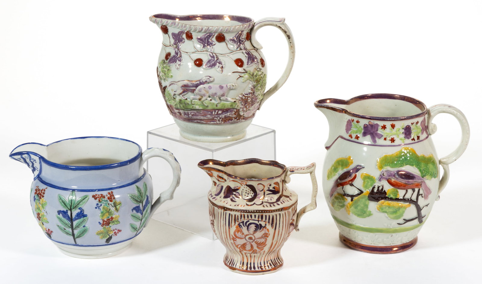 BRITISH HAND-PAINTED CERAMIC JUGS / PITCHERS, LOT OF FOUR: BRITISH HAND-PAINTED CERAMIC JUGS / PITCHERS, LOT OF FOUR, comprising one creamer with pink lustre designs and ribbed body including a floral vine below rim and three examples with embossed polychrome