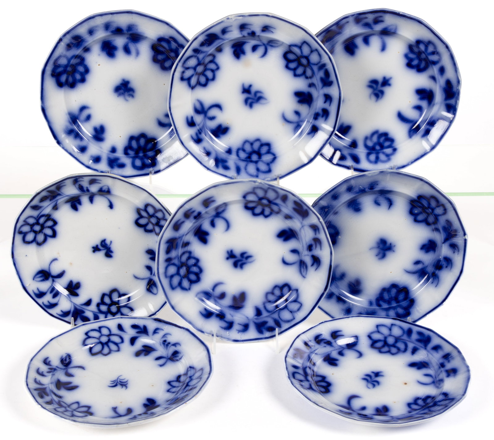 ENGLISH BRUSH-STROKE FLOW BLUE FLORAL MOTIF IRONSTONE PLATES, SET OF EIGHT: ENGLISH BRUSH-STROKE FLOW BLUE FLORAL MOTIF IRONSTONE PLATES, SET OF EIGHT, each featuring hand-painted Daisy Seven Petal design. Unmarked. Mid 19th century. 10 1/4" D. Literature: Williams 