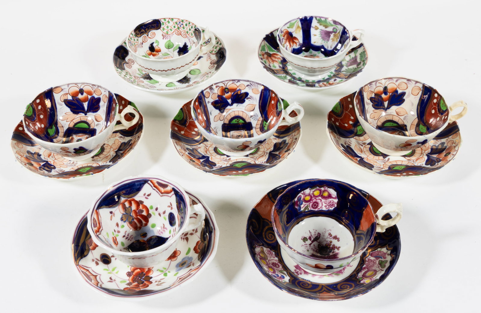 BRITISH GAUDY WELSH FLORAL MOTIF CERAMIC CUP AND SAUCER SETS, LOT OF SEVEN: BRITISH GAUDY WELSH FLORAL MOTIF CERAMIC CUP AND SAUCER SETS, LOT OF SEVEN, including one having Nightingale bird pattern, one featuring Serenade pattern, one having Drape pattern, one with Bethel pat