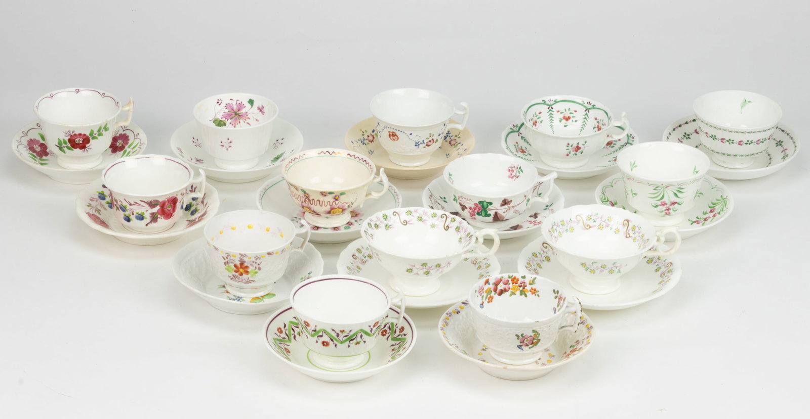 BRITISH HAND-PAINTED CERAMIC FLORAL MOTIF CUP AND SAUCER SETS, LOT OF 14: BRITISH HAND-PAINTED CERAMIC FLORAL MOTIF CUP AND SAUCER SETS, LOT OF 14, each having polychrome decorations, including one example with grape bunch motif, two sets having matching delicate green and 