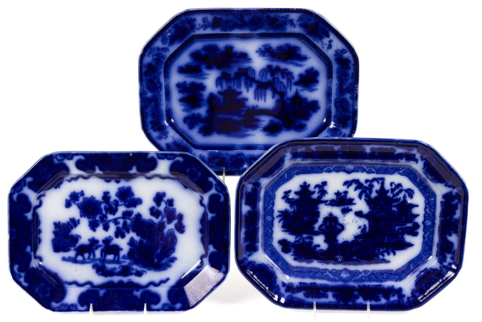 ENGLISH STAFFORDSHIRE FLOW BLUE CHINOISERIE MOTIF IRONSTONE PLATTERS, LOT OF THREE: ENGLISH STAFFORDSHIRE FLOW BLUE CHINOISERIE MOTIF IRONSTONE PLATTERS, LOT OF THREE, each of elongated octagonal form, comprising one example having "CASHMERE" pattern depicting two deer amon