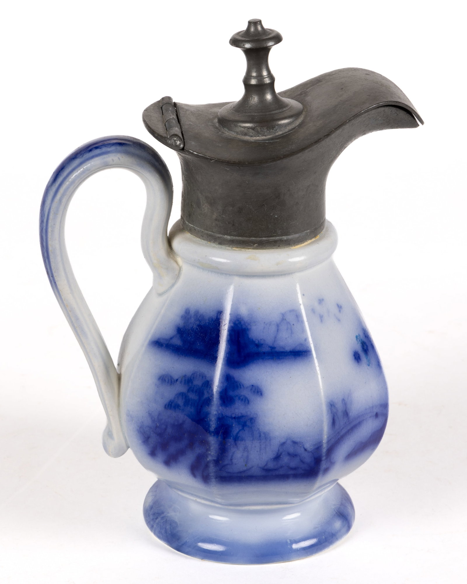 ENGLISH STAFFORDSHIRE FLOW BLUE CHINOISERIE MOTIF IRONSTONE SYRUP: ENGLISH STAFFORDSHIRE FLOW BLUE CHINOISERIE MOTIF IRONSTONE SYRUP, having a panel-form body and a hinged metal lid, featuring Hong Kong pattern depicting pagodas and two figures on a bridge. Charles M