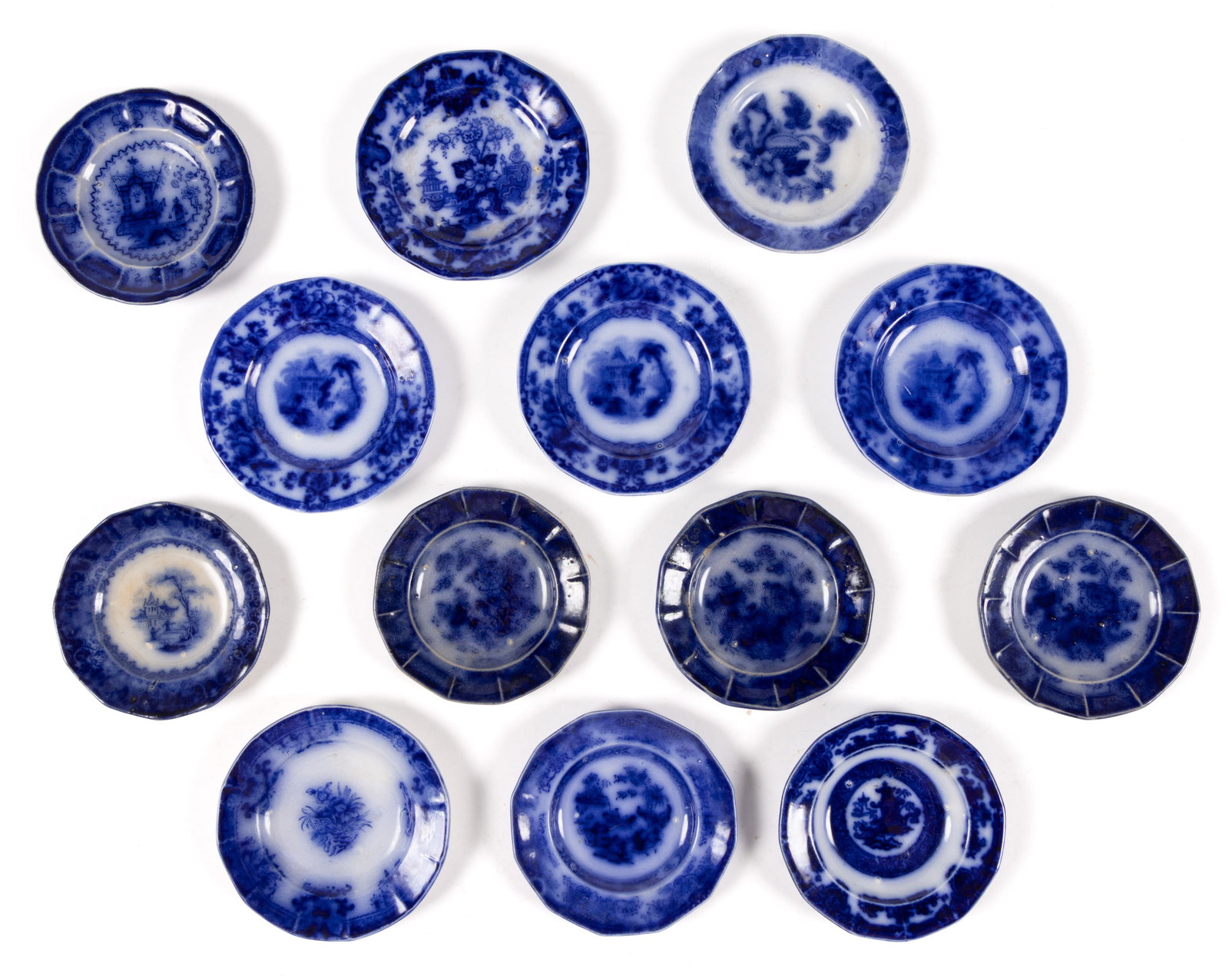 ENGLISH STAFFORDSHIRE FLOW BLUE IRONSTONE CUP PLATES, LOT OF 13: ENGLISH STAFFORDSHIRE FLOW BLUE IRONSTONE CUP PLATES, LOT OF 13, comprising patterns "ARABESQUE", "CYPRUS", "SCINDE", Temple, Tonquin, Oregon, Amoy, Indian Jar, 