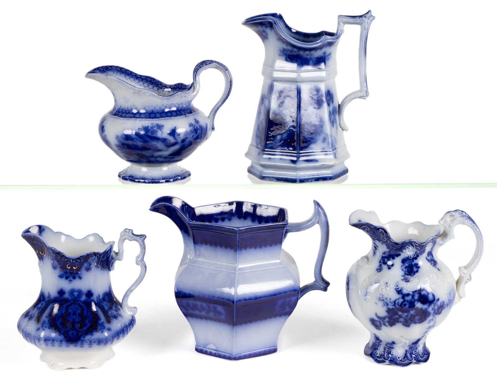 ENGLISH AND GERMAN FLOW BLUE FLORAL AND OTHER MOTIF IRONSTONE JUGS / PITCHERS, LOT OF FIVE: ENGLISH AND GERMAN FLOW BLUE FLORAL AND OTHER MOTIF IRONSTONE JUGS / PITCHERS, LOT OF FIVE, including "INDIA" featuring two birds, a Villeroy & Bock octagonal-form example havi