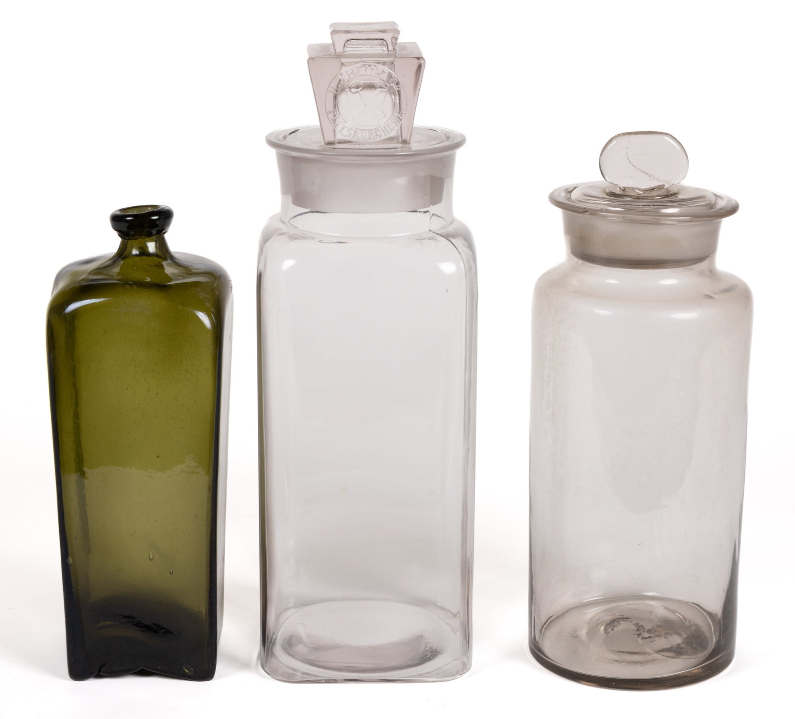 ANTIQUE BOTTLE AND JARS, LOT OF THREE: ANTIQUE BOTTLE AND JARS, LOT OF THREE, comprising a black glass/deep olive green Dutch case gin bottle with crude applied mouth and rough pontil mark; a colorless square store jar embossed for H. J.