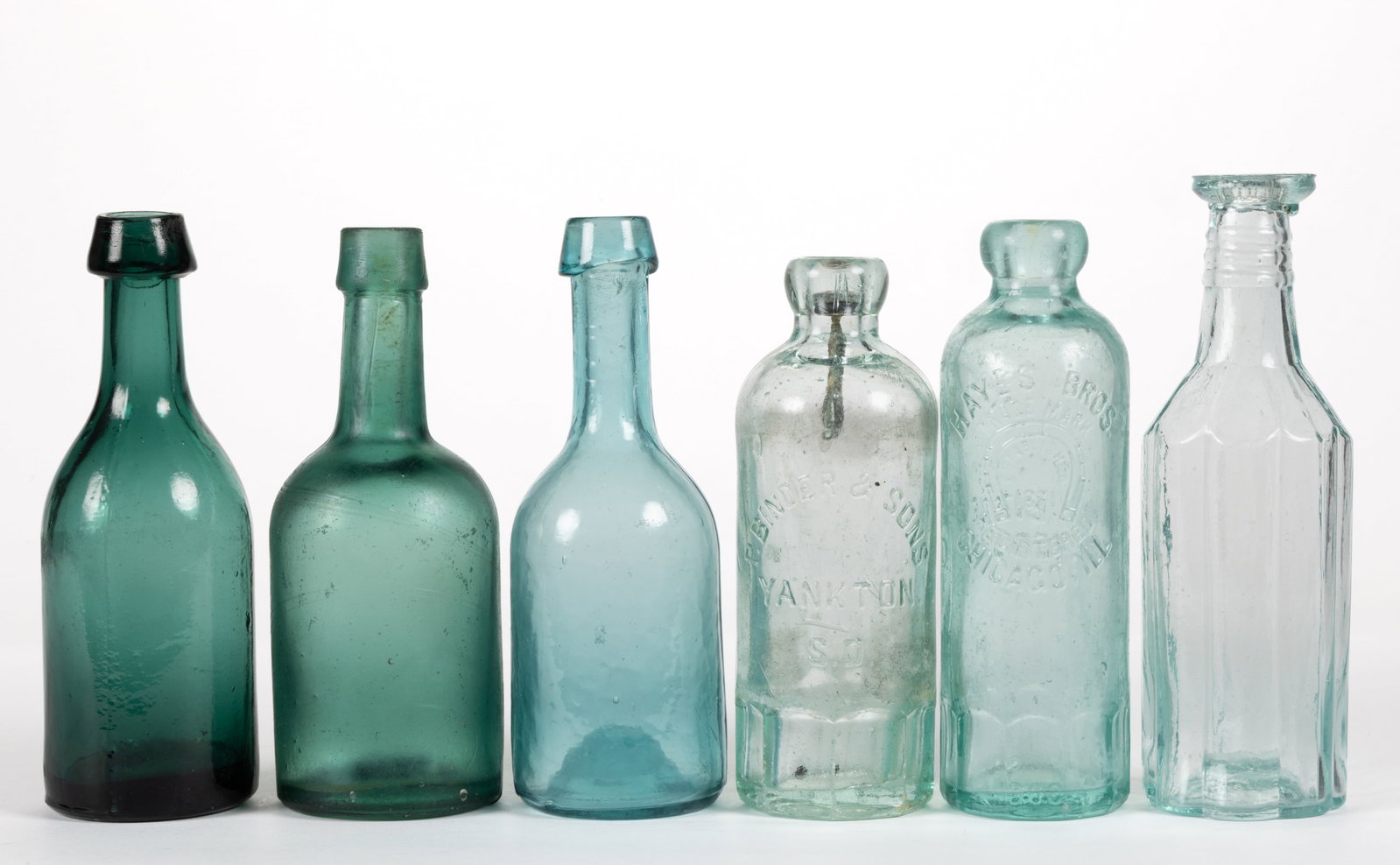ASSORTED BLOWN-MOLDED GLASS BOTTLES, LOT OF SIX: ASSORTED BLOWN-MOLDED GLASS BOTTLES, LOT OF SIX, aquamarine and teal green, comprising two Hutchinson forms, one embossed "HAYES BROS. / TRADE MARK / REGISTERED / CHICAGO, ILL." around