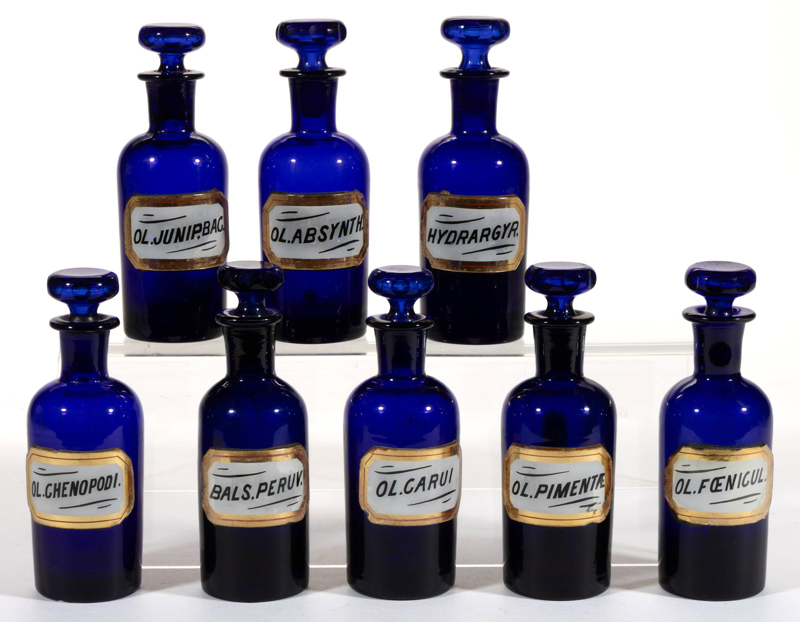LABEL UNDER GLASS APOTHECARY BOTTLES / JARS, LOT OF EIGHT: LABEL UNDER GLASS APOTHECARY BOTTLES / JARS, LOT OF EIGHT, cobalt blue, each cylindrical form with tooled mouth, having painted and gilt labels to front indicating contents including