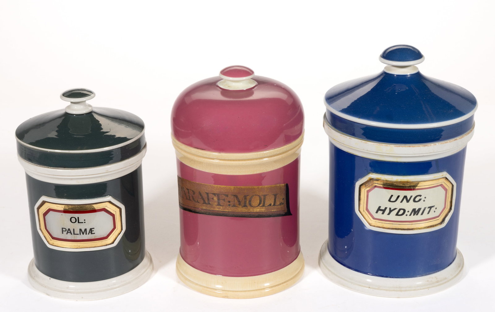 ENGLISH CERAMIC APOTHECARY JARS, LOT OF THREE: ENGLISH CERAMIC APOTHECARY JARS, LOT OF THREE, each of cylindrical form with original cover, two with applied label-under-glass to the front and one with a painted label, two impressed with