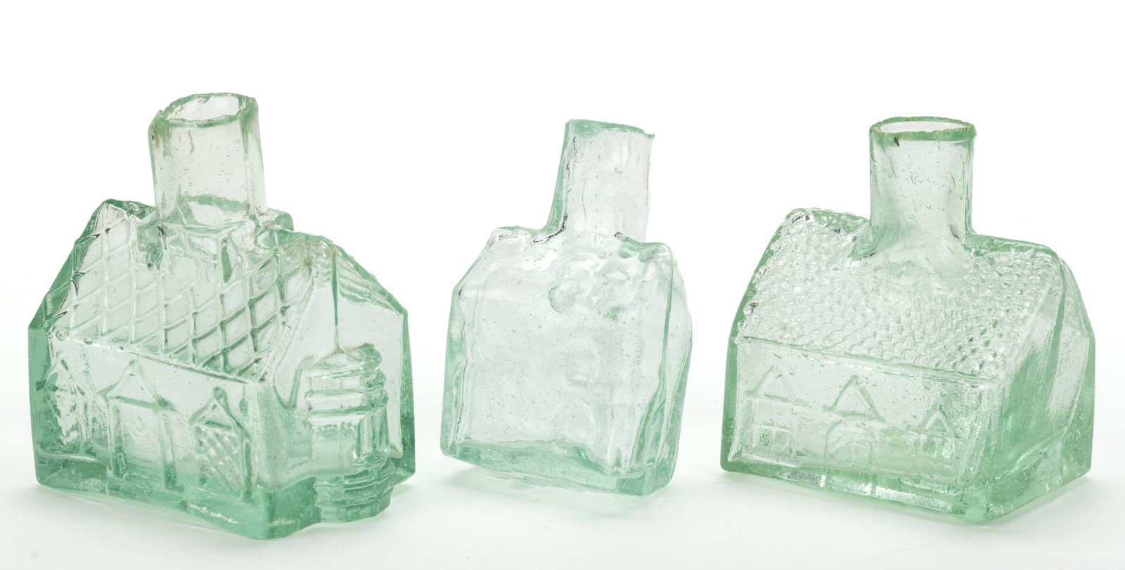 COTTAGE / HOUSE FIGURAL INKWELLS / BOTTLES, LOT OF THREE: COTTAGE / HOUSE FIGURAL INKWELLS / BOTTLES, LOT OF THREE, aquamarine, the large example with barrel embossed "C. CHANDLER / & Co." under the base, two largest examples with a pen gr