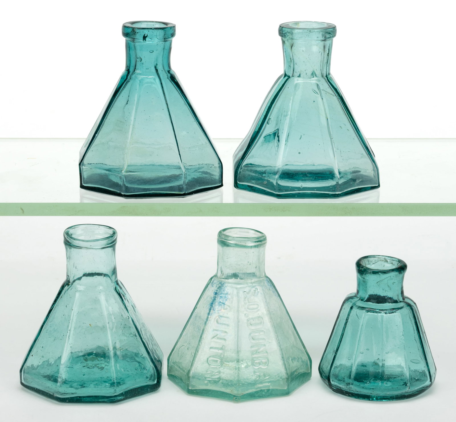 ASSORTED CONICAL PANELLED UMBRELLA INKWELLS / BOTTLES, LOT OF FIVE: ASSORTED CONICAL PANELLED UMBRELLA INKWELLS / BOTTLES, LOT OF FIVE, shades of aquamarine and blue-green, comprising one 12-sided and four octagonal, one embossed "S.O. DUNBAR / TAUNTON" and 