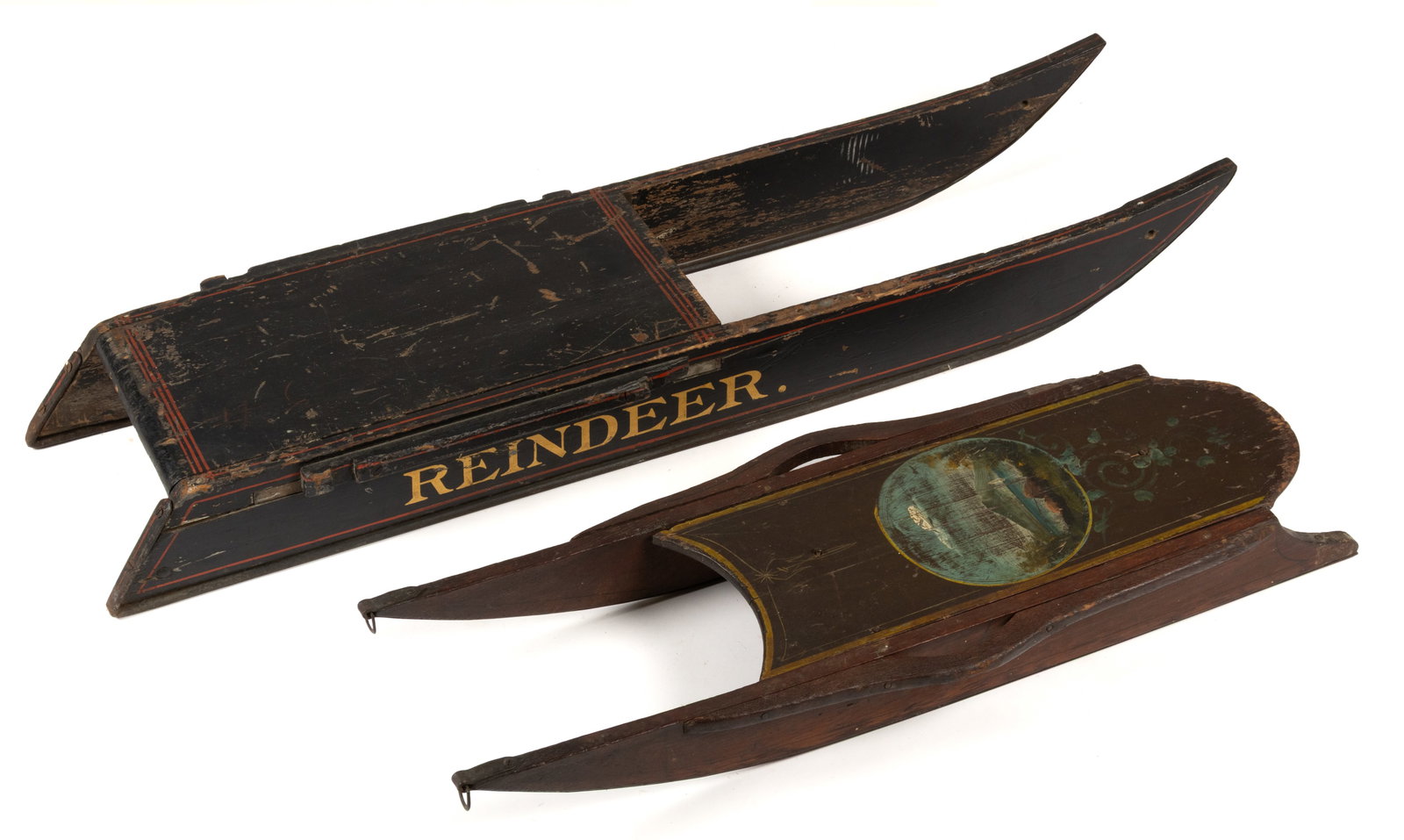 AMERICAN FOLK ART PAINT-DECORATED WOODEN CHILD'S SLEDS, LOT OF TWO: AMERICAN FOLK ART PAINT-DECORATED WOODEN CHILD'S SLEDS, LOT OF TWO, comprising one large black sled with iron runners, red detailing, and "Reindeer" in gold lettering on the side, a