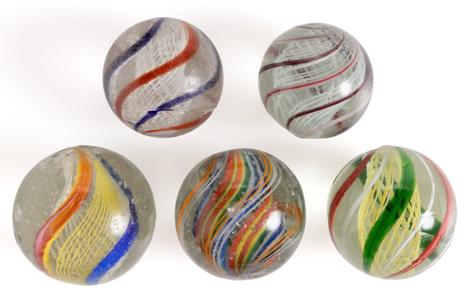 ANTIQUE TRANSPARENT SWIRL LATTICINIO CORE GLASS MARBLES, LOT OF FIVE: ANTIQUE TRANSPARENT SWIRL LATTICINIO CORE GLASS MARBLES, LOT OF FIVE, comprising two examples with white latticinio cores, one with a yellow latticinio core, one with divided multicolor 