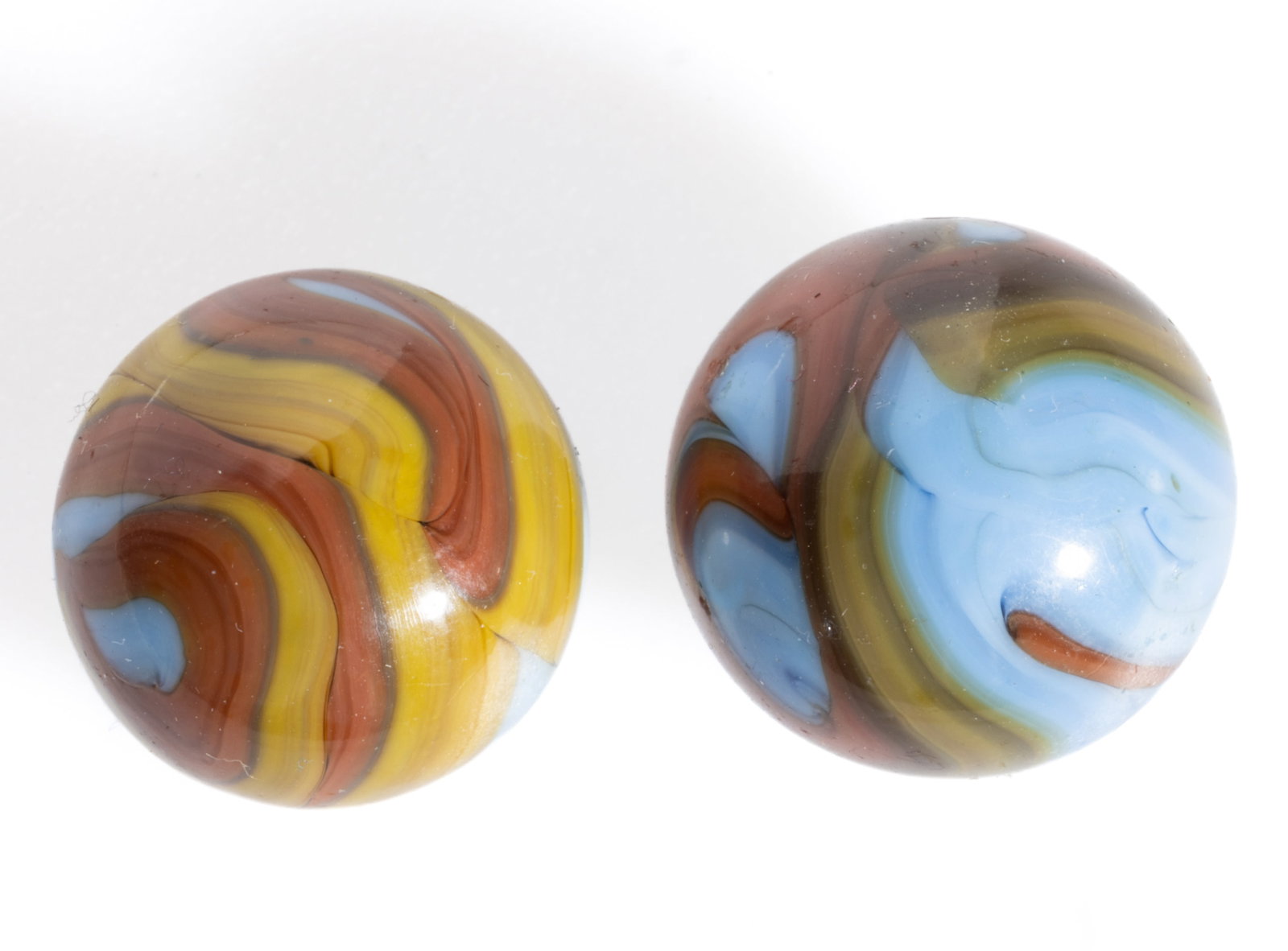 CHRISTENSEN OPAQUE SWIRL MACHINE-MADE MARBLES, LOT OF TWO: CHRISTENSEN OPAQUE SWIRL MACHINE-MADE MARBLES, LOT OF TWO, opaque blue base color, each with yellow, brown, and orange swirl decoration. Christensen Agate Co. 1925-1930. 5/8" and 21/32&