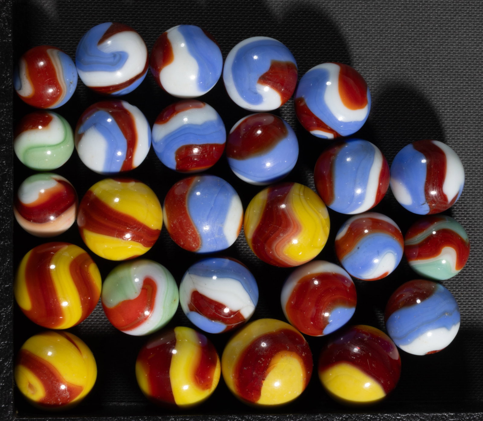 AKRO AGATE CORKSCREW MACHINE-MADE MARBLES, LOT OF 26: AKRO AGATE CORKSCREW MACHINE-MADE MARBLES, LOT OF 26, various colors and combinations, including seven Prize Name and fifteen Liberty. Akro Agate Co. 1925-1935. 21/32" to 1" D. Pro