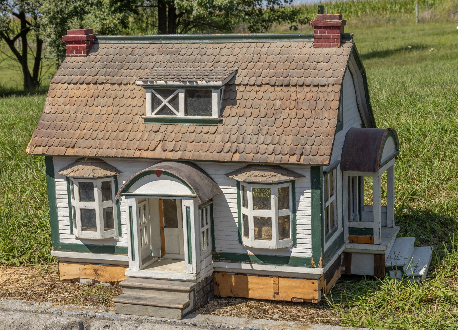 LARGE CHILD'S WOODEN DOLLHOUSE: LARGE CHILD'S WOODEN DOLLHOUSE, Dutch Colonial style having a gambrell-style roof form with shaker/wooden shingles, painted white with dark green trim to the roof, windows and corners;&n