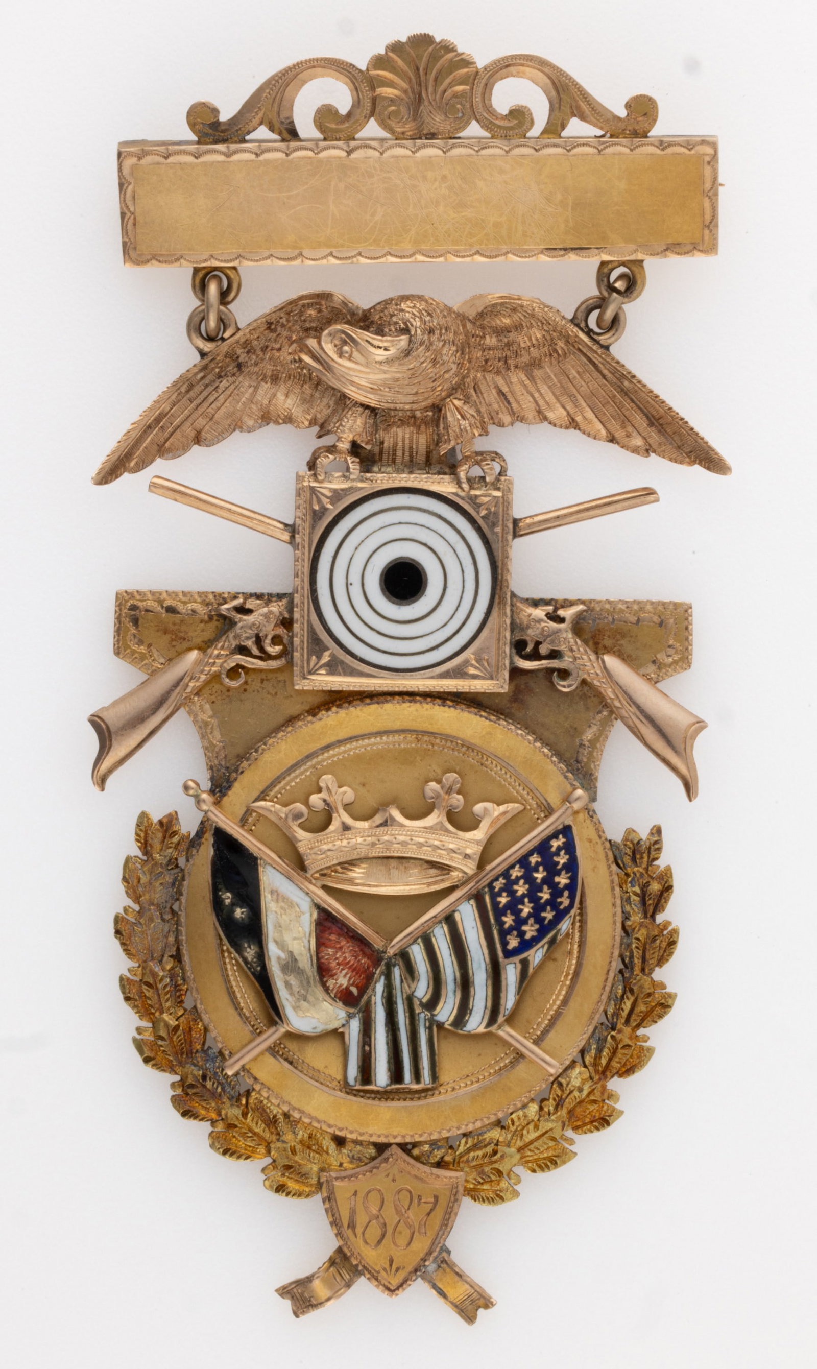 1887 RIFLEMAN / SHOOTING 10K GOLD MEDAL: 1887 RIFLEMAN / SHOOTING 10K GOLD MEDAL, bar pin with scroll and shell decoration along top edge, below with a large panel of a spread-wing eagle clutching an enameled target with crossed rifles behin