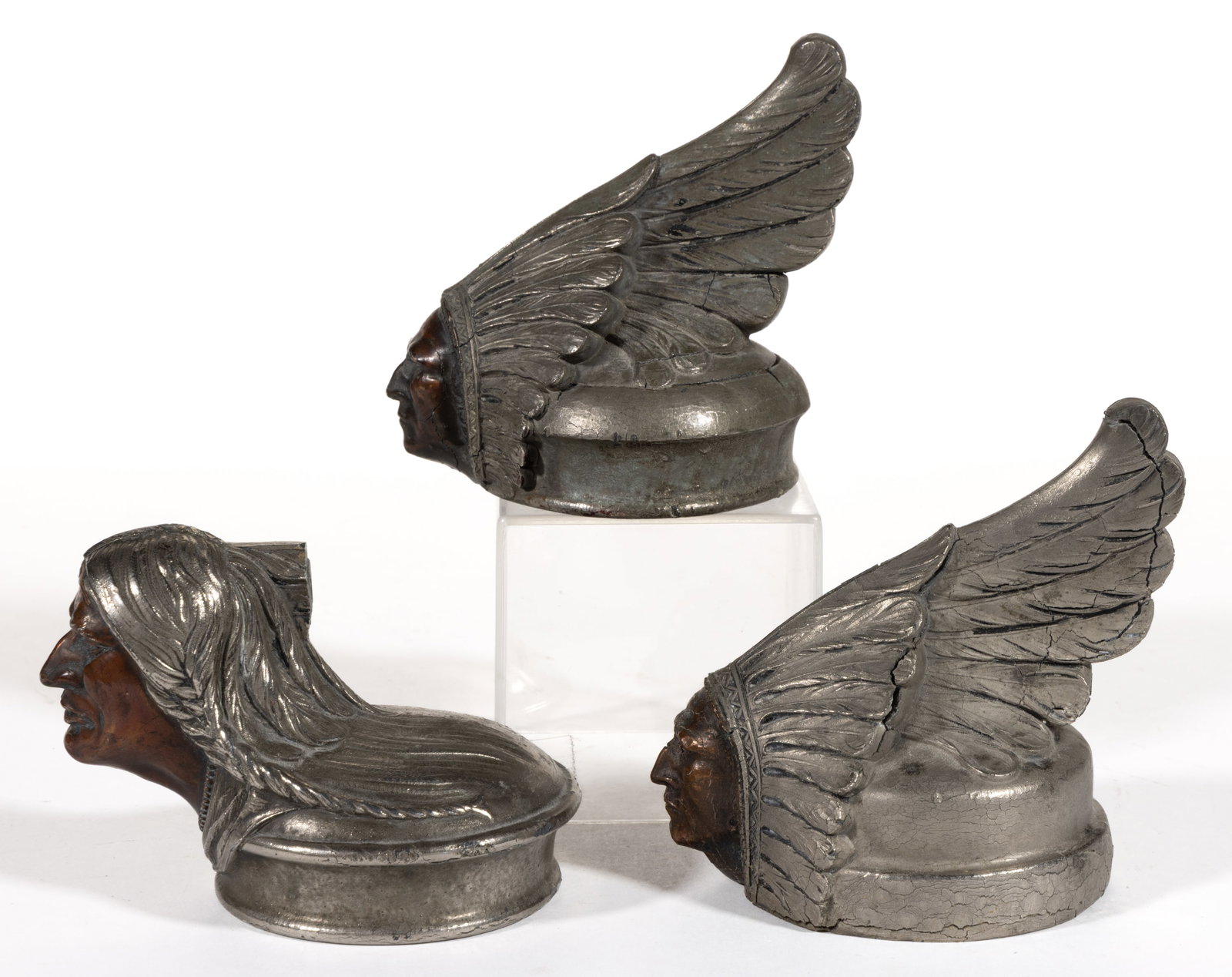 PONTIAC CHIEF AUTOMOBILE MASCOTS / HOOD / RADIATOR ORNAMENTS, LOT OF THREE: PONTIAC CHIEF AUTOMOBILE MASCOTS / HOOD / RADIATOR ORNAMENTS, LOT OF THREE, nickel-plated and patinated, comprising two 1927 models depicting Native American / Indian Chief heads with tall headdr